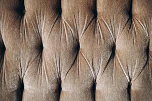 Textile pattern featuring tufted fabric in neutral brown tones with intricate details photo