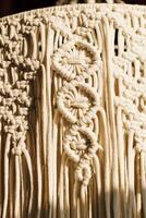 Intricate macrame textile design featuring unique knots and patterns crafted with natural fibers photo