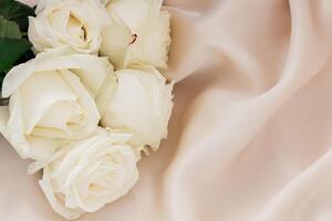 White roses on silk create a serene ambiance for a special occasion photo