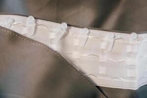 Detailed view of garment fasteners showing white hooks and loops on soft fabric photo