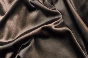 Luxurious dark fabric with elegant drapes and soft texture in natural light photo