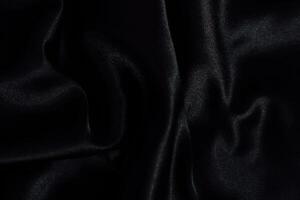 Elegant black fabric drapery showcases texture and sheen in a soft light setting photo