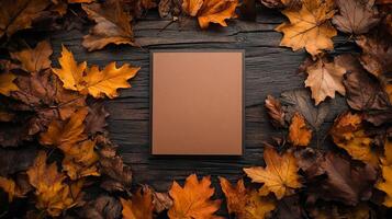 Autumn Leaves Frame with Blank Brown Paper Card on Rustic Wood Background photo