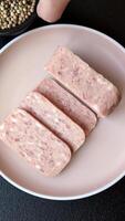 Canned ham, meat, pork, with spices and salt, slices on a dark concrete background video