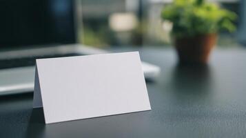 Blank White Card Mockup On Dark Desk With Laptop And Plant photo