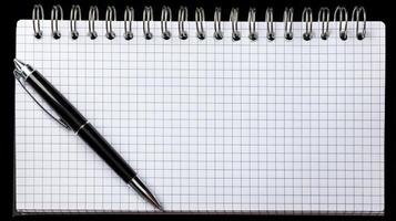 Minimalist Flatlay of Office Supplies Black Pen on Grid Notebook photo