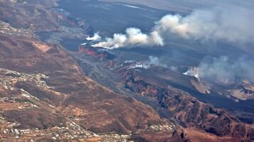 Aerial View of Volcanic Crater with Steam and Smoke Plumes photo