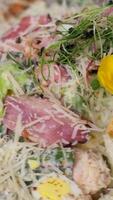 Caesar Salat dekoriert mit essbar Blumen großzügig bestreut mit Käse und Wachtel Eier Schüssel von frisch Caesar Salat auf das Tabelle video