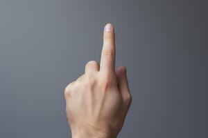Male hand pointing up with index finger on gray background photo