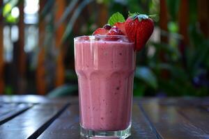 Refreshing strawberry smoothie sitting on table in lush garden setting photo