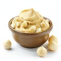 Macadamia nut butter in bowl with macadamia nuts topping photo