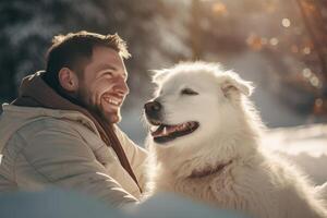 Man smiling and having fun with his dog in the snow during winter photo