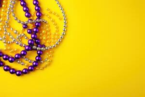 Mardi gras beads on yellow background creating festive atmosphere for celebration photo