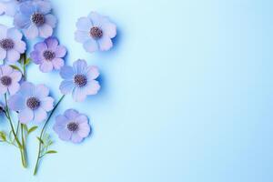 Purple flowers arranged on a pastel blue background with copy space photo