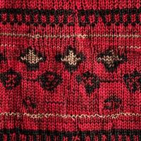 Red and black knitted wool fabric showing intricate design and texture photo