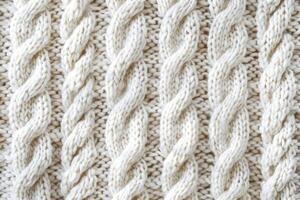 Cable knit white wool sweater texture creating repeating vertical braid pattern photo