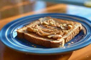 Toasted bread with peanut butter and peanuts on blue plate photo
