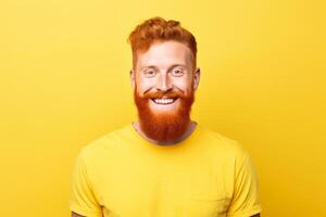 Portrait of smiling bearded ginger man wearing yellow t shirt on yellow background photo
