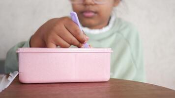 Child pick strawberry using fork from a pink box video