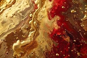 Mixing red and gold paints creating abstract swirls and bubbles photo