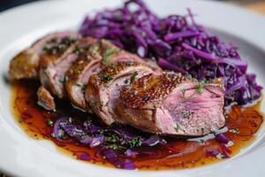 Sliced duck breast with red cabbage and balsamic glaze on white plate photo