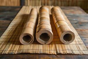 Bamboo mat and rolled up bamboo stalks resting on wooden table photo