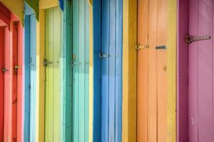 Colorful beach huts creating a vibrant rainbow pattern on the coastline photo