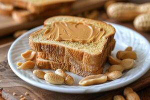 Toasted bread slices with creamy peanut butter and peanuts on white plate photo
