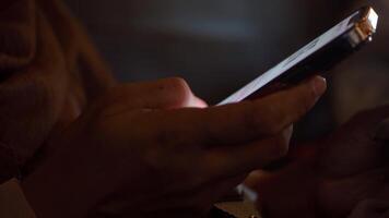 Using a smartphone in low light during a cozy evening video