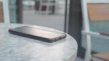 Smartphone resting on a table in a quiet outdoor setting video