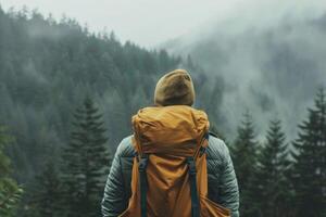 Hiker contemplating foggy forest during hiking trip in misty mountains photo
