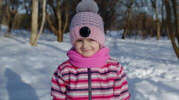 Smiling child kid looking at camera, showing tongue, fooling around, making faces in winter park video
