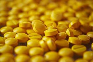 Close up of yellow pills creating compelling medical background photo
