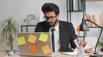 Tired sad exhausted businessman working on laptop at office with many sticker tasks, panic attack video