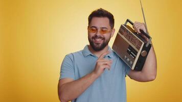Happy man using retro tape record player to listen music disco dancing of favorite track having fun video