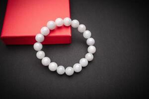 Close-up of a white jade bangle or bracelet on a black background. Space for text. photo