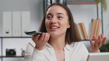 Young business woman working, having mobile phone talk at office workplace using messenger chat apps video