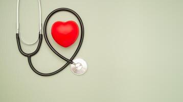 Cardiology specialist. Top view of a stethoscope and a red heart shape on a green background. photo
