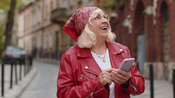 Senior woman using smartphone typing text messages looking for a way on map in mobile navigator app video
