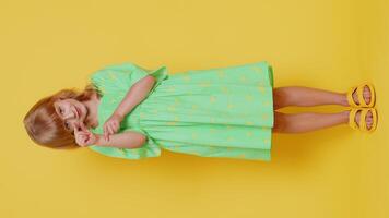 Child girl showing a little bit gesture with sceptic smile showing minimum sign measuring small size video