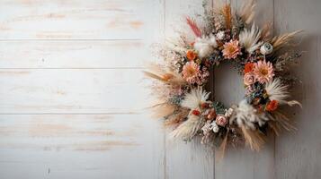 A decorative wreath made of dried flowers and grasses against a rustic wooden background. photo