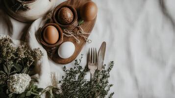 A rustic arrangement featuring eggs, a fork, and dried flowers on a textured surface, evoking a cozy, natural atmosphere. photo