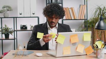 Tired sad exhausted businessman working on laptop at office with many sticker tasks, panic attack video