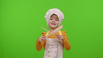 Child girl dressed in apron like chef cook dancing with fork and spatula on chroma key background video