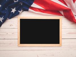 Part of the American flag and a mini chalkboard on a wooden table. Space for text. photo