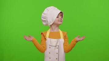Child girl kid dressed cook chef in apron pointing at right and left on blank space, chroma key video