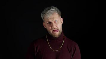 Comical stupid stylish man making funny silly face grimace, playing fool, showing tongue, brainless video