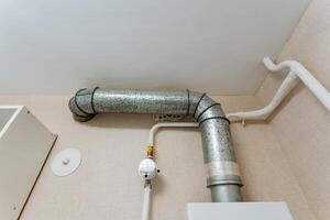 A metal pipe is currently suspended from the ceiling of a room, creating an intriguing focal point that may be part of the plumbing system or the infrastructure of the space photo