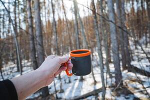 In the tranquil woods, a person finds profound solace while savoring a warm cup of delicious coffee, embracing the beauty of nature all around for deep reflections and inner calm photo