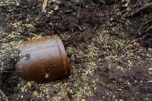 A rusty and grimy old bucket is resting in the dry, parched soil, highlighting the serious and urgent issue of pollution and waste accumulation that is affecting the entire area photo